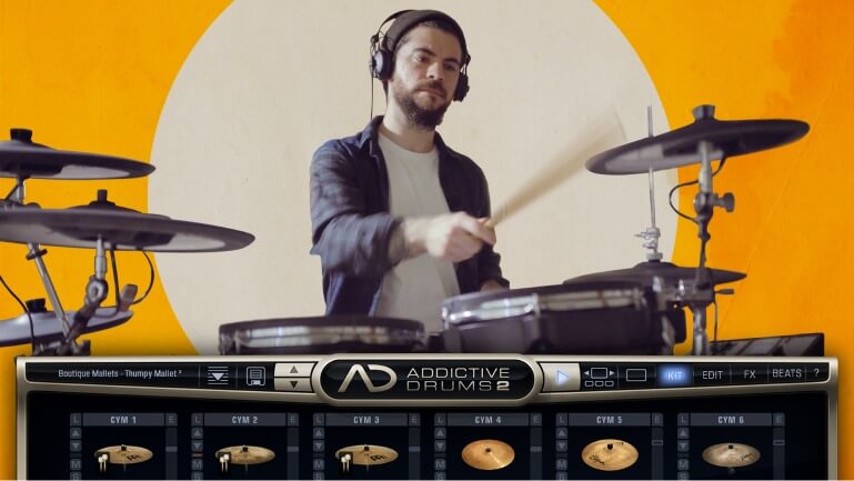 Drummer playing on electronic drum kit with Addictive Drums 2 software loaded in